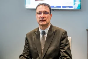 Conseiller funéraire en costume sombre dans une agence de pompes funèbres.