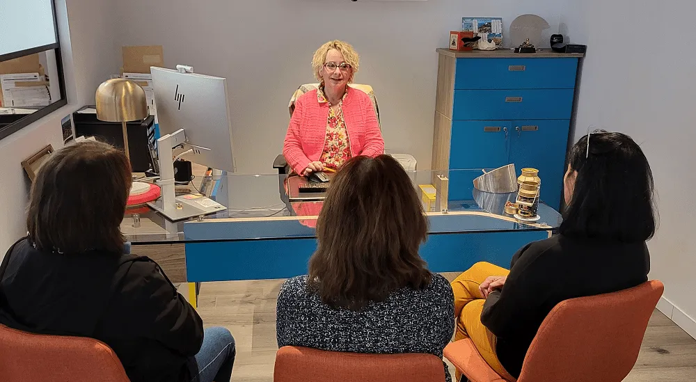 Conseillère funéraire recevant une famille dans un bureau pour l'organisation d'obsèques.